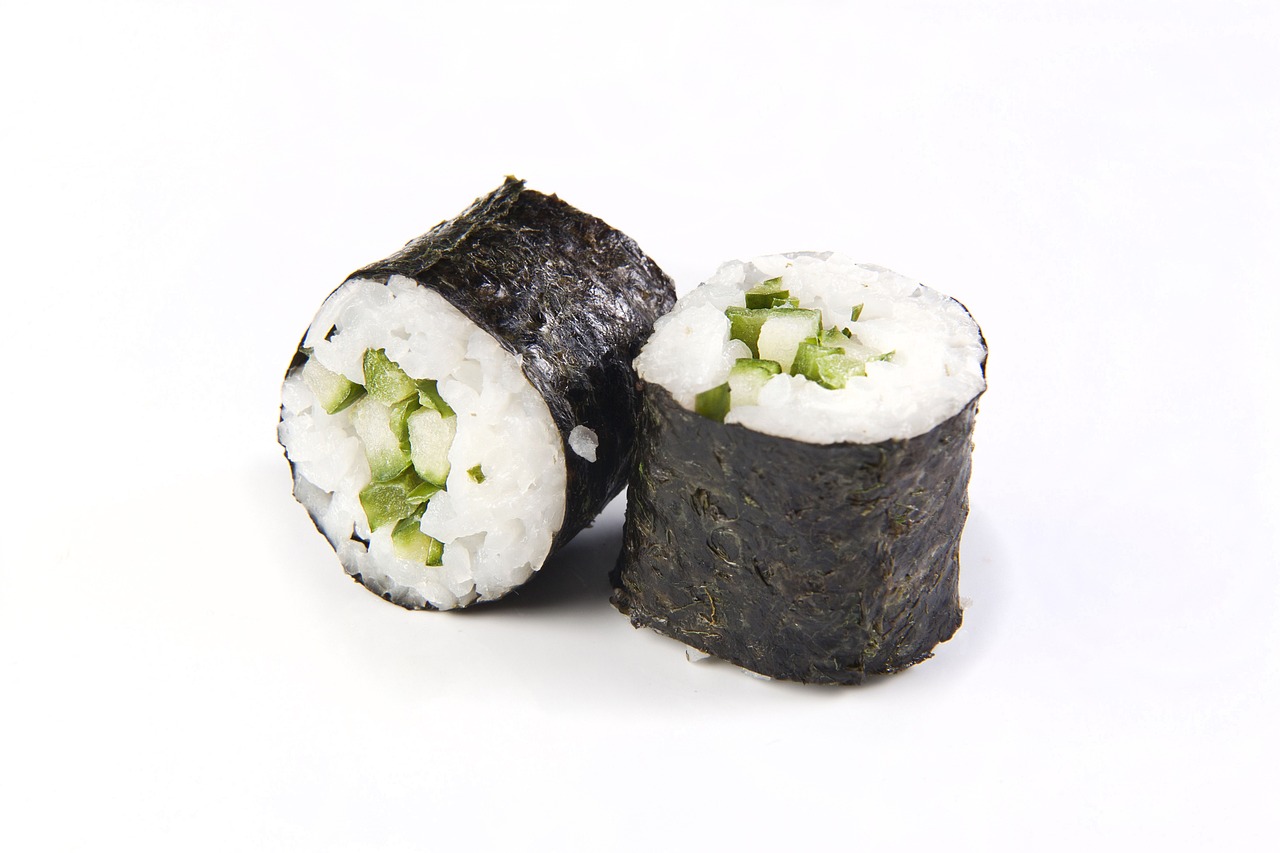 two cucumber sushi rolls on white background